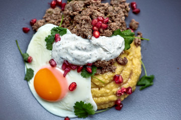 Breakfast - fried egg, beans, tomatoes, mushrooms, garnet. Mexican fried eggs huevos rancheros and ingredients close-up on the table.