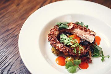 The process of eating the delicious grilled octopus. jukkumi bokkeum is korea traditional webfoot octopus with vegetable stir fry.