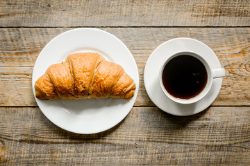 coffee and croissant for breakfast of businessman wooden office desk background top view