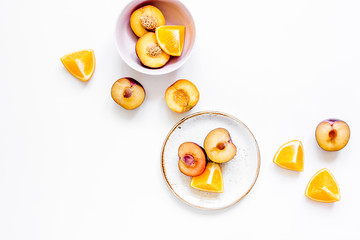 cut peach and orange for exotic fruit on plates white background top view mockup