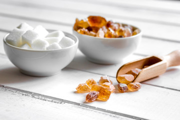 variety of sugar in bowls on white wooden table background