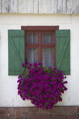 A window of a mountain cottage house decorated with flowers