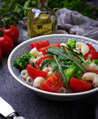 Salad with pasta, tomatoes, broccoli and arugula