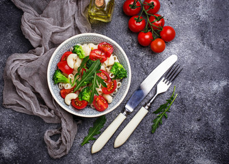 Salad with pasta, tomatoes, broccoli and arugula