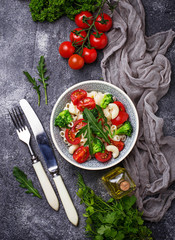 Salad with pasta, tomatoes, broccoli and arugula