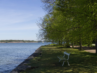 A bench under green trees on Suomenlinna, Helsink, Finland