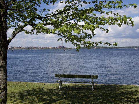 A bench under green trees on Suomenlinna, Helsink, Finland