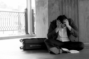 Stressed asian businessman bankrupt with sitting at outdoor.