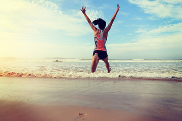 young fitness woman wear swimsuit running and jumping on beach