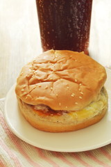 chicken hamburger and cola with ice in plastic cup
