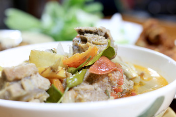 hot and spicy soup with pork ribs with Thai herb in white blow on the table for dinner. Thai style food.
