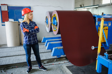 woman in red safety helmet at metal tile roof manufacturing factory