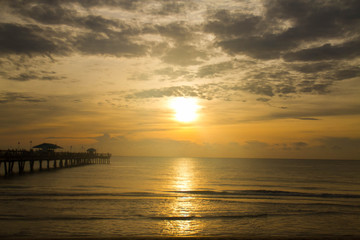 Fototapeta na wymiar Sunrise reflects on the dark ocean