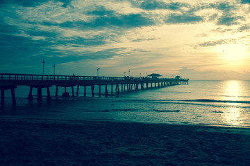 Long pier along the beach with sunrise in vintage style