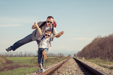 Father and son walking on the railway at the day time.