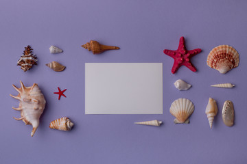 Summer background: Paper card mock-up composed wonderfully with seashells on purple table. Top view. Flat lay.