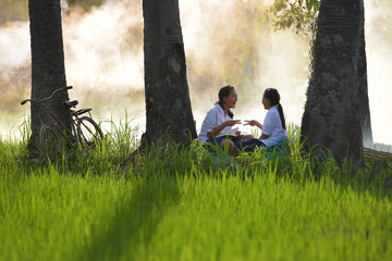 Schoolchildren painting something exercise books outdoor at summer