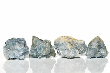 Set of four Celestine crystals on white background with reflection