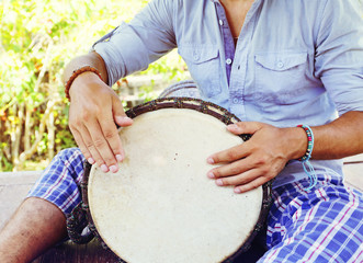 man playing on djembe