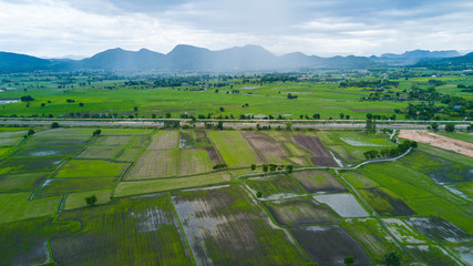 Fototapeta na wymiar landscape panorama with view of green field and mountains on rainy day