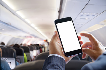 Airplane passenger using smart phone on plane. Businessman touching blank screen mobile phone at...