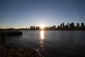 Fototapeta premium Sunset behind Manhattan reflects on East river