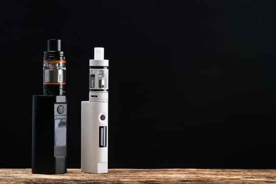 Two electronic cigarettes on a dark background