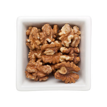 Roasted walnut in a square bowl isolated on white background