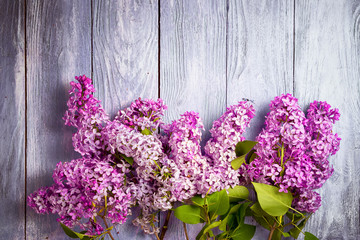 bunches of lilac on a wooden table top view with copy space above