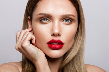 Beautiful young model with red lips and nude manicure