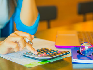 woman working with calculator, business document and laptop computer notebook