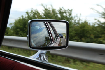 Road in car mirror