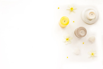 Beauty spa composition. White and yellow candles, iris flowers, sea shells and on white background. Flat lay, top view, copy space