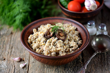 Buckwheat with chicken and mushrooms on an old wooden background. Rustic style.