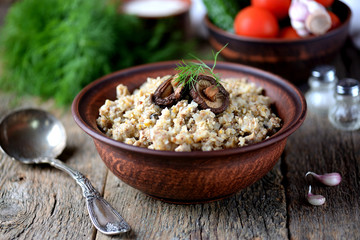 Buckwheat with chicken and mushrooms on an old wooden background. Rustic style.