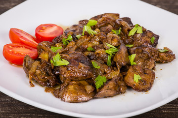Chicken livers in a creamy sauce with onion on white plate