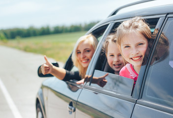 Beautiful blonde mom while driving a car with her children