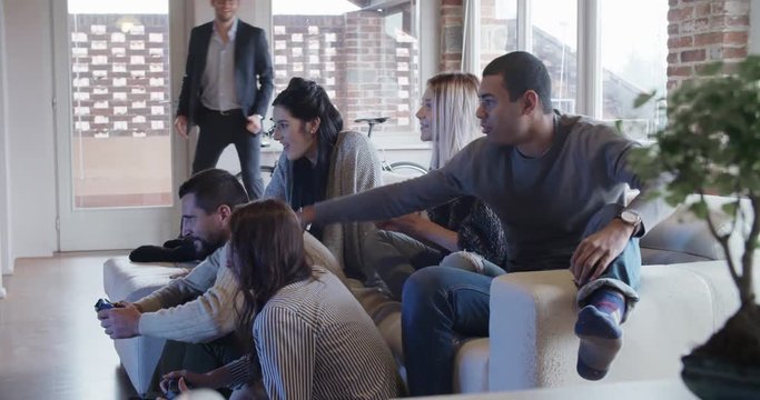 multiethnic group of friends people enjoy relaxing on couch playing videogames and having fun indoor in modern industrial house. 4k handheld video shot