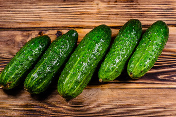 Ripe tomatoes and cucumbers on wooden table. Top view