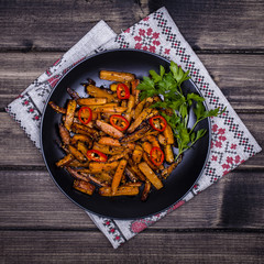 Roasted carrots in black plate, close up