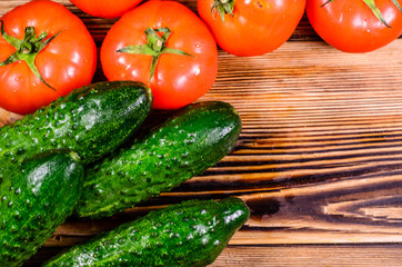 Ripe tomatoes, radish and cucumbers on wooden table. Top view