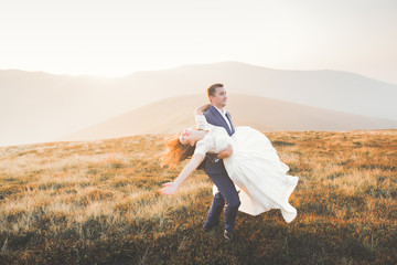 Wedding couple posing on sunset at wedding day. Bride and groom in love