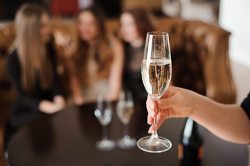 glass of champagne on the background of friends at a party