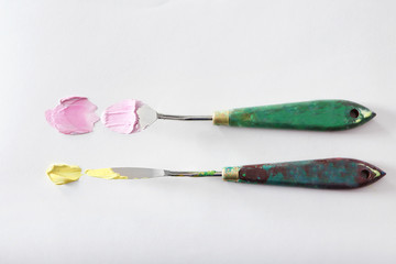 Palette knives with oil paints on white paper