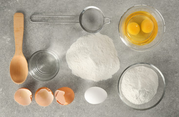 Set of products for making dough on grey background