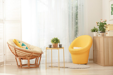 Beautiful modern veranda with cozy armchairs and coffee table