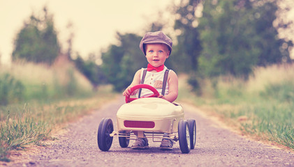Kind fährt im nostalgischen Tretauto