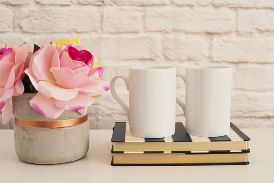 Two Mugs. White Mugs Mockup. Blank White Coffee Mug Mock Up. Styled Photography. Coffee Cup Product Display. Two Coffee Mugs On Striped Design Notebooks. Vase With Pink Roses