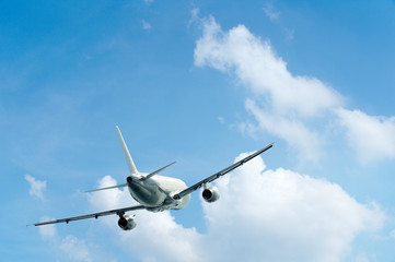 Fototapeta na wymiar Airplane is flying in a blue sky