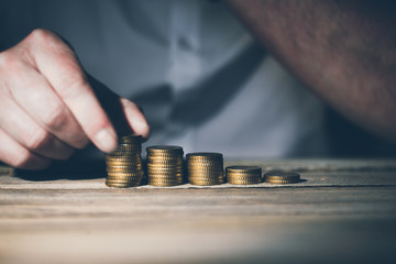 Stacking money coins, business casual man on table